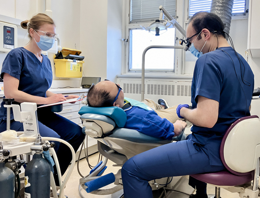 A group of people working around a patient on a dental chair