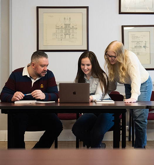 A group of people looking at a computer