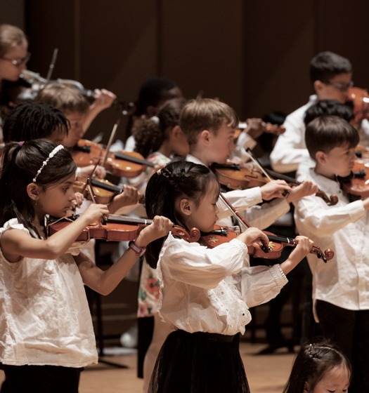 A group of children playing violins