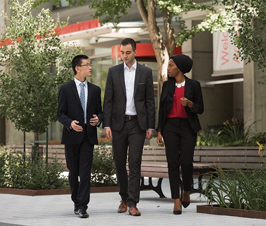 A group of people walking on a sidewalk