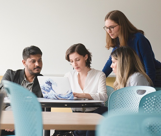 A group of people looking at a computer